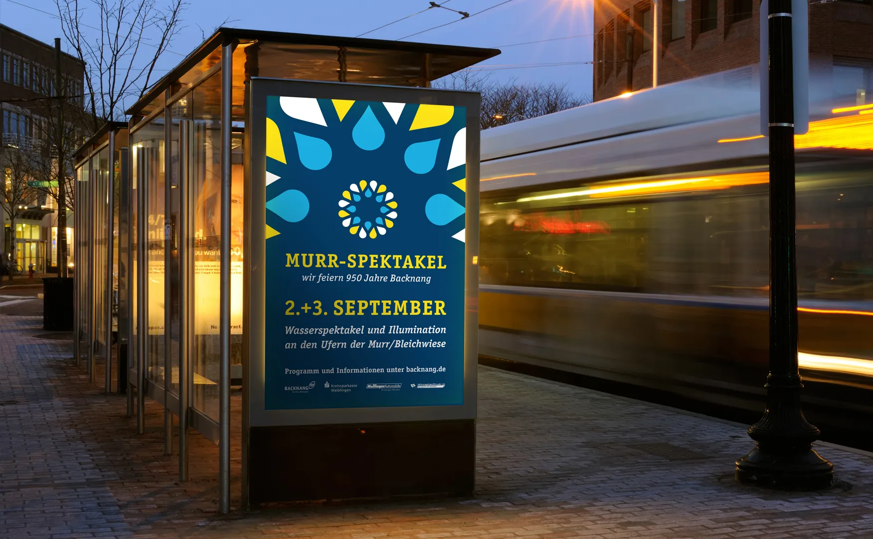 Citylight-Plakat des Murr-Spektakels an einer beleuchteten Haltestelle am Abend