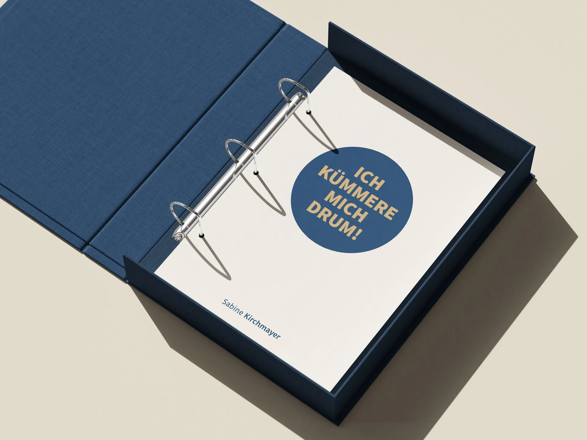 Blauer Ringordner mit Deckblatt im Corporate Design: großer Kreis mit dem Satz „Ich kümmere mich drum!“