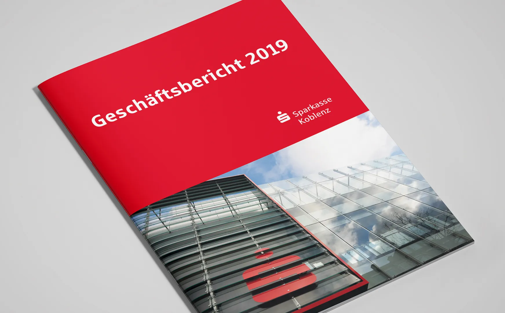 Titelseite des Geschäftsberichts 2019 der Sparkasse Koblenz mit rotem Feld und Glasfassade