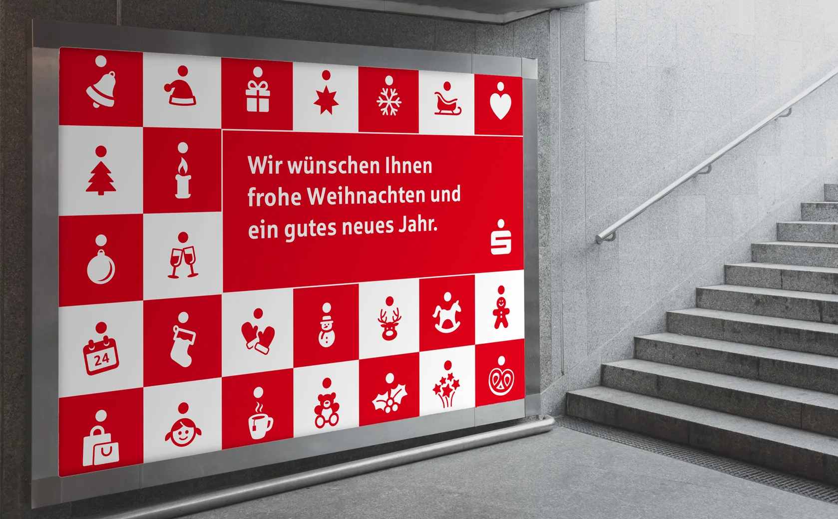 Großflächenplakat mit Weihnachtsgruß der Sparkasse Koblenz in einer Unterführung neben einer Treppe