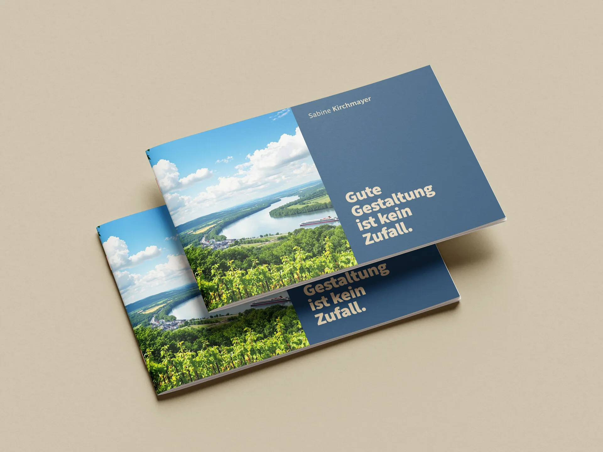 Zwei Broschüren im Querformat mit Rheinlandschaft und dem Satz „Gute Gestaltung ist kein Zufall.“