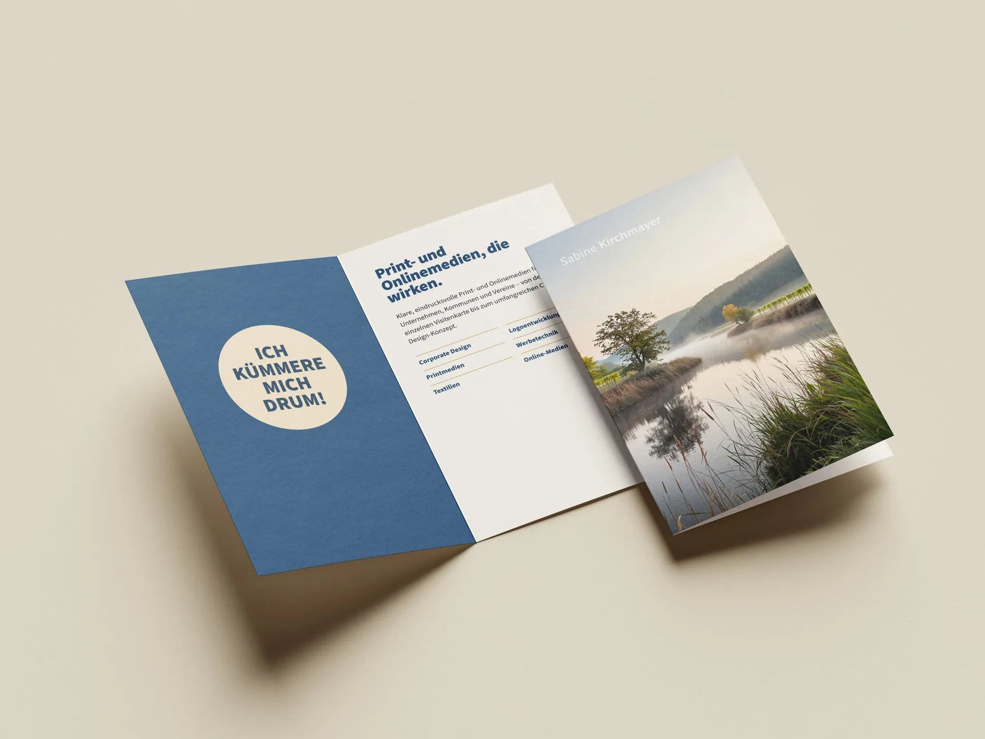 Gefalteter Flyer mit blauer Innenseite, Leistungsübersicht und einem ruhigen Flussmotiv auf der Titelseite