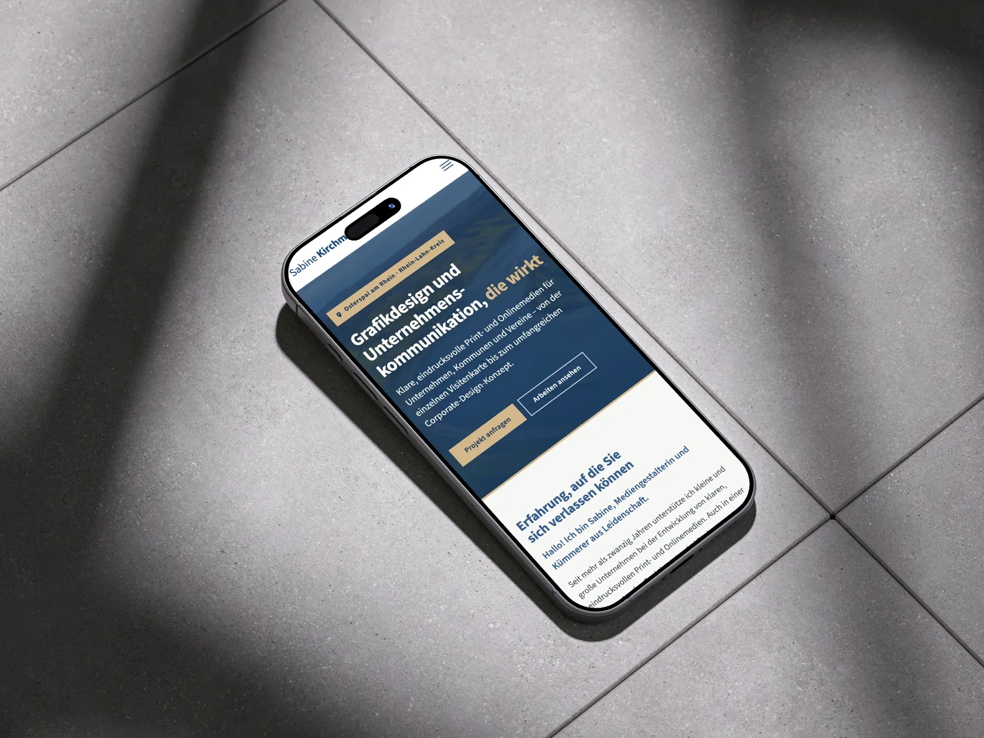 Smartphone mit der mobilen Ansicht der Website: Rheinpanorama, Überschrift und Schaltflächen