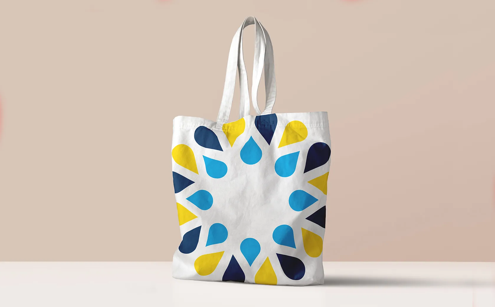 Weiße Stofftasche mit dem Tropfenkranz des Murr-Spektakels in Gelb und Blau