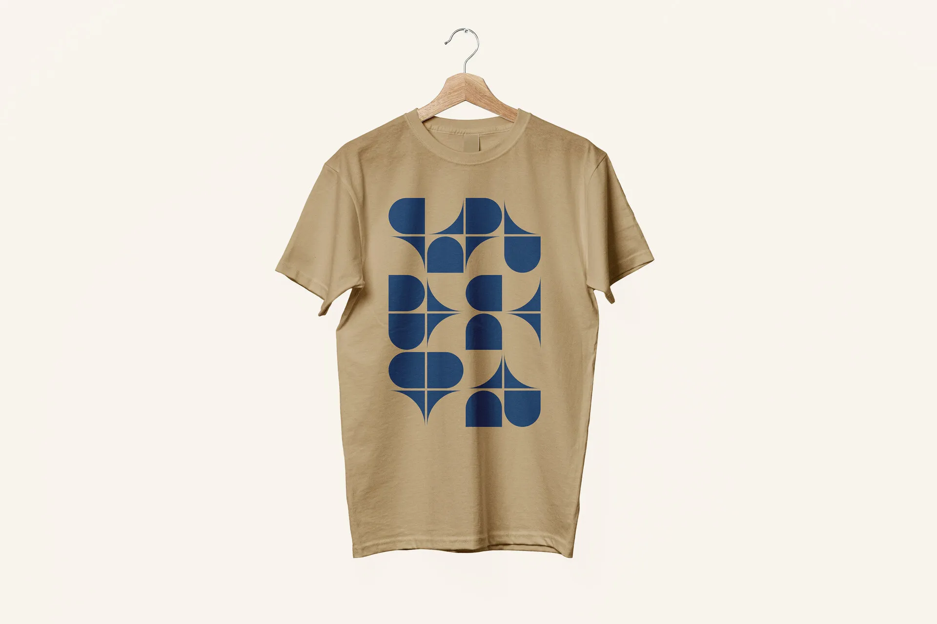 Dunkelbeiges T-Shirt am Bügel mit blauem Grafikdruck aus Halb- und Viertelkreisen