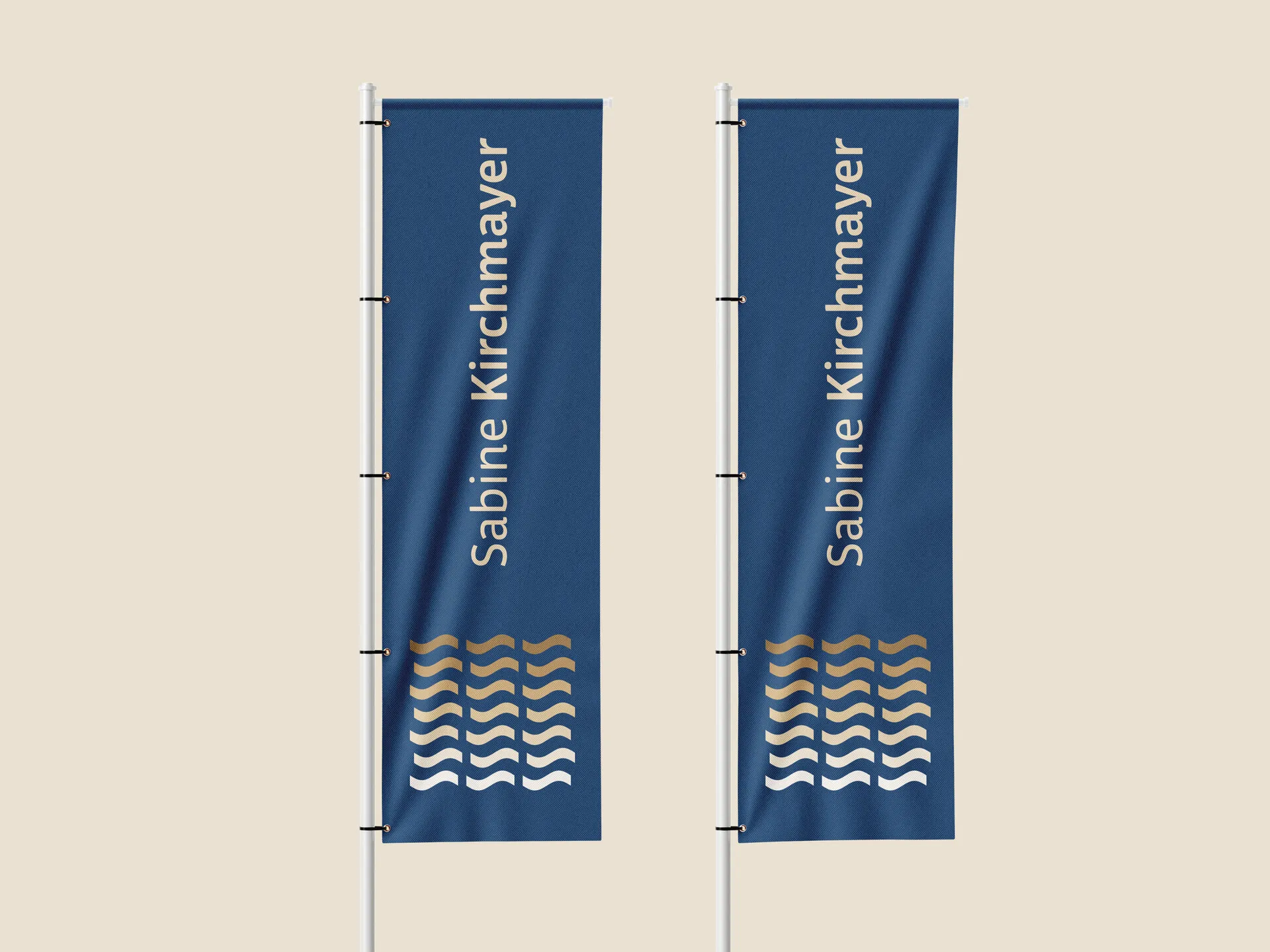 Zwei blaue Beachflags mit senkrechtem Schriftzug Sabine Kirchmayer und goldenem Wellenmotiv