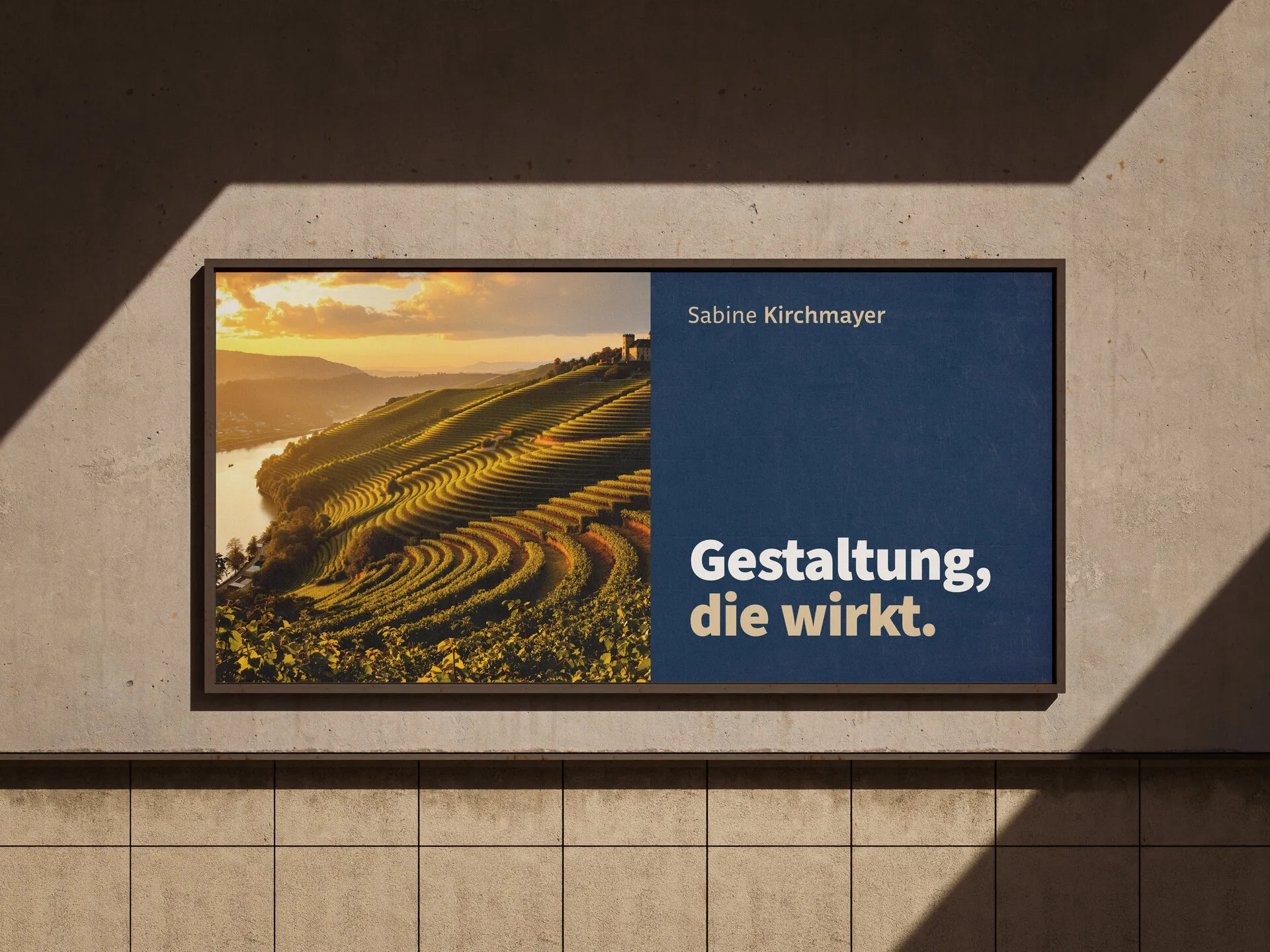 Plakatwand an einer Hausfassade mit Weinbergfoto und dem Satz „Gestaltung, die wirkt.“